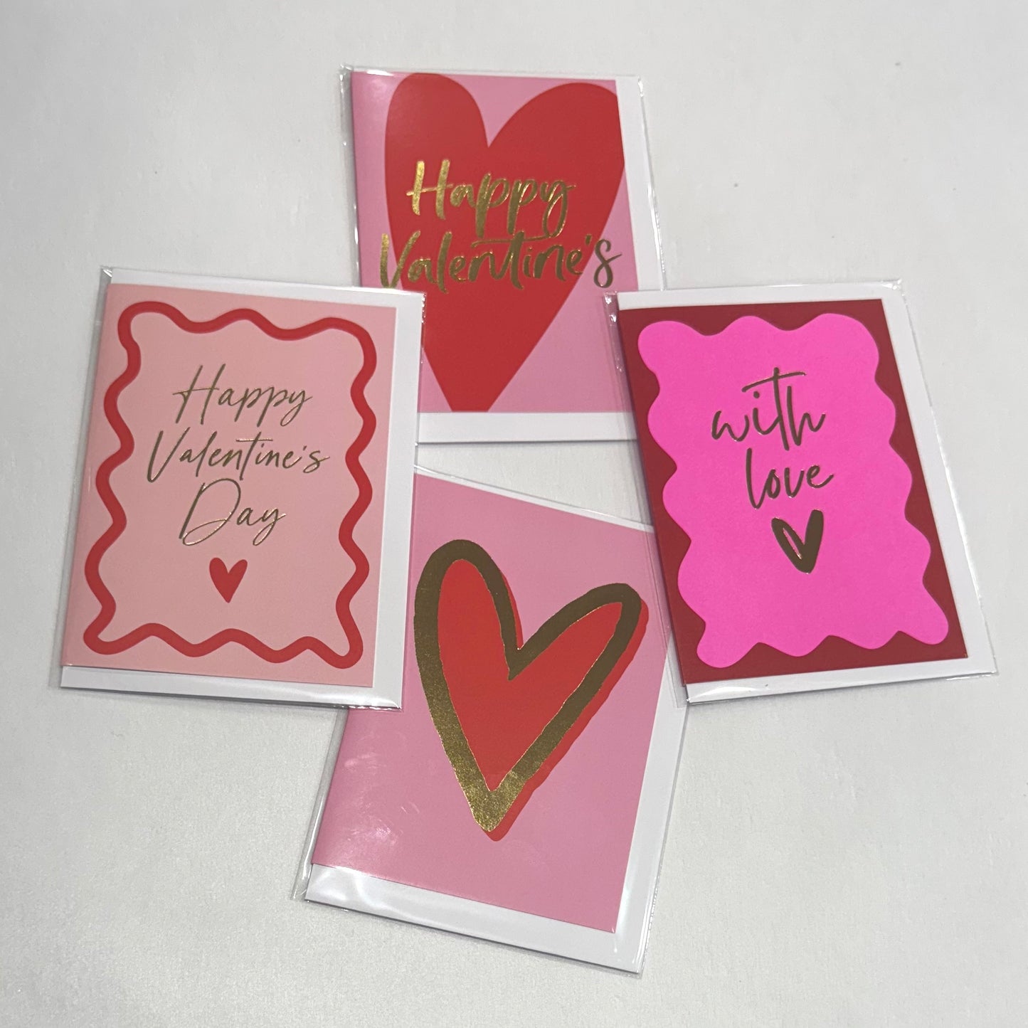 Four Valentine's Day greeting cards from Flowers on Norton St, featuring red and pink heart designs, are displayed on a white background. Messages include "Happy Valentine's," "with love," and more.