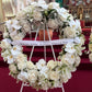 A Large Wreath by FlowersonNortonSt is elegantly displayed on a stand.