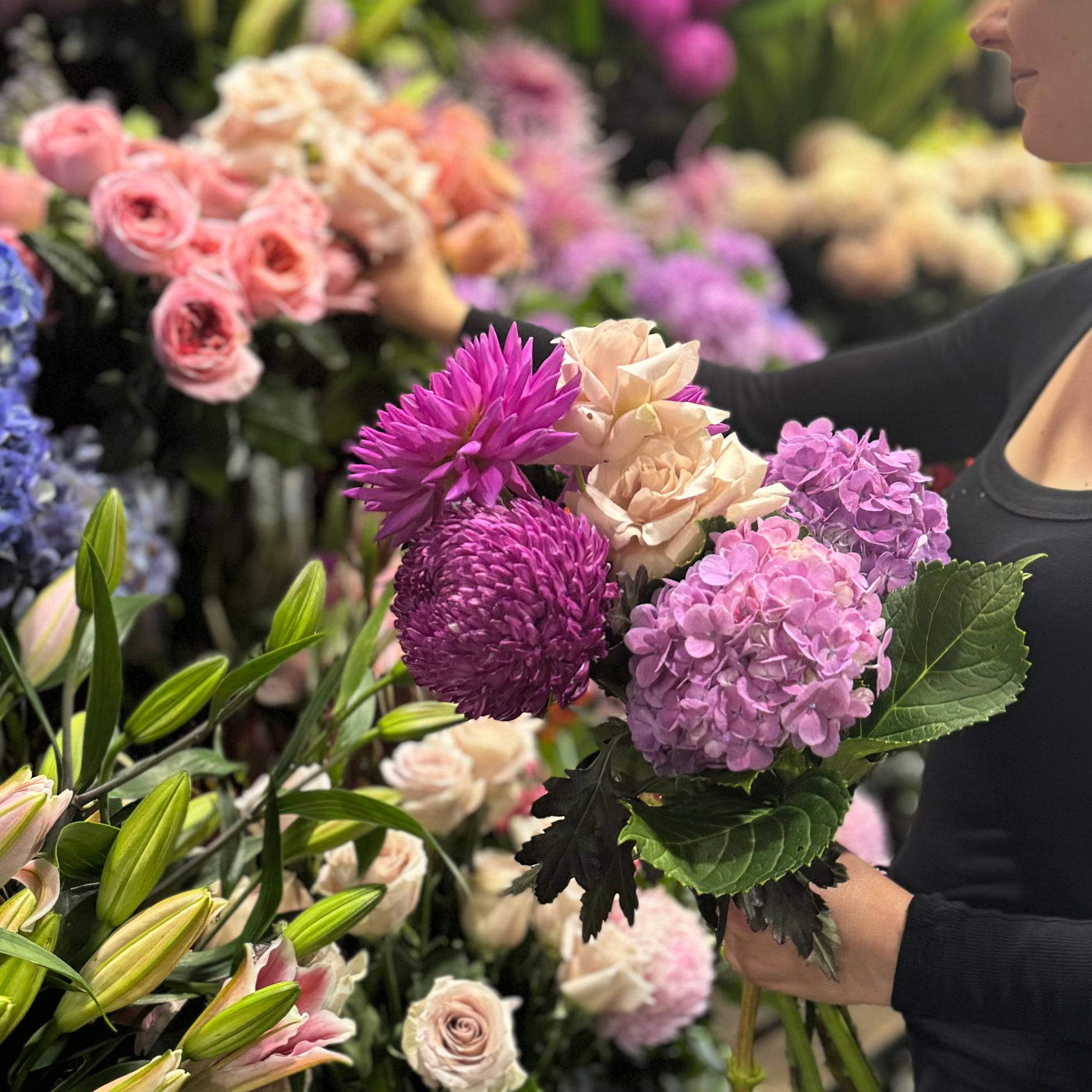 A woman holding a stunning Florist Choice bouquet, highlighting the vibrant charm of Flowers on Norton St's expert Sydney flower delivery service.