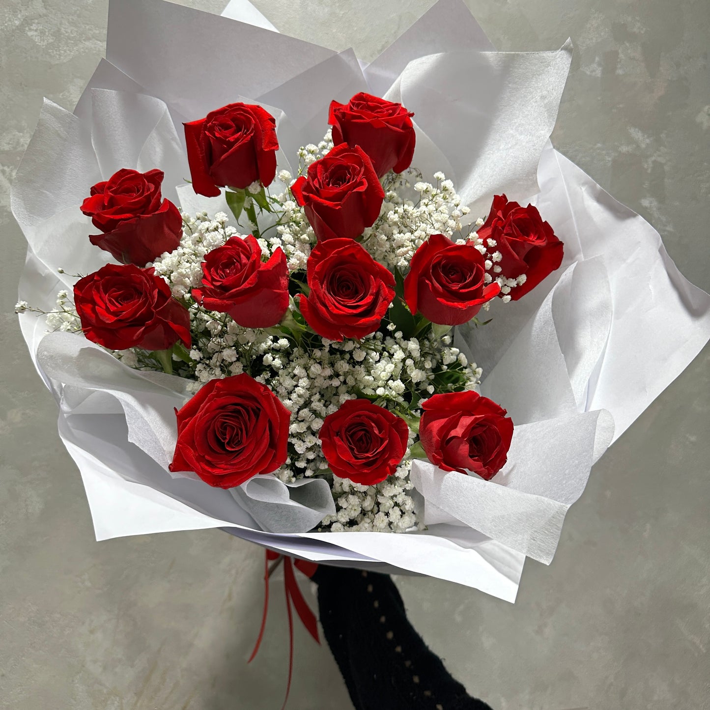 The Classical Lovers Red Rose Bouquet by Flowers on Norton St features red roses and delicate white baby's breath, elegantly wrapped in crisp white paper.