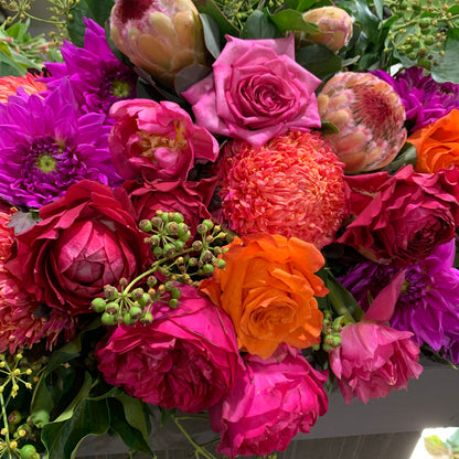 Explore the Florist Choice - Bright by Flowers on Norton St, a vibrant arrangement featuring pink roses, orange roses, deep pink peonies, and purple dahlias. Lush green foliage and small green buds enhance the rich colors of this bouquet. Delight in this beauty with affordable flower delivery Sydney or online flower delivery Sydney.