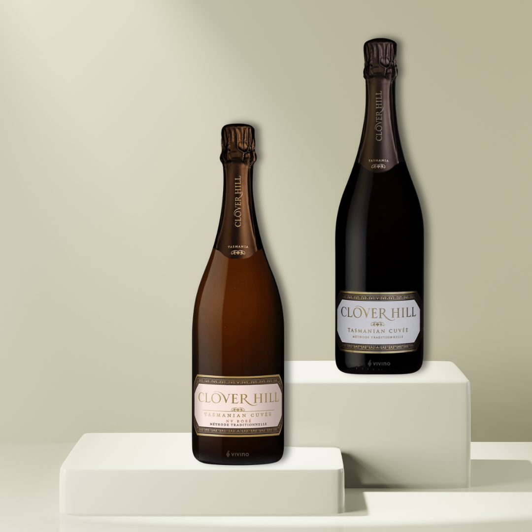 Two bottles of Clover Hill Sparkling Wine from the Flowers on Norton St brand are showcased on white platforms against a neutral background. The bottles, with their elegant labels, exude sophistication and are arranged at varying heights.